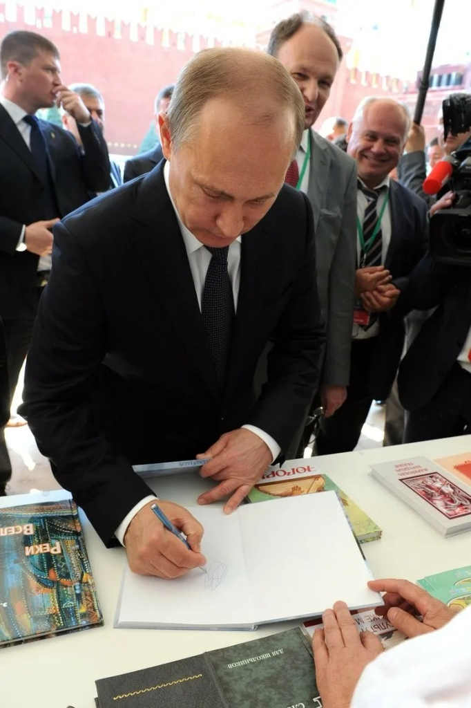 путин подписывает книгу.png