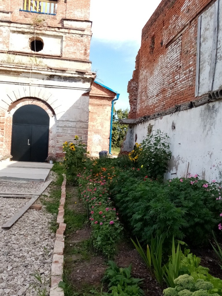 По расчищенной дорожке, мимо цветов люди приходят в восстанавливающийся храм, который выбрали сердцем. (Фото Натальи Кулишовой).